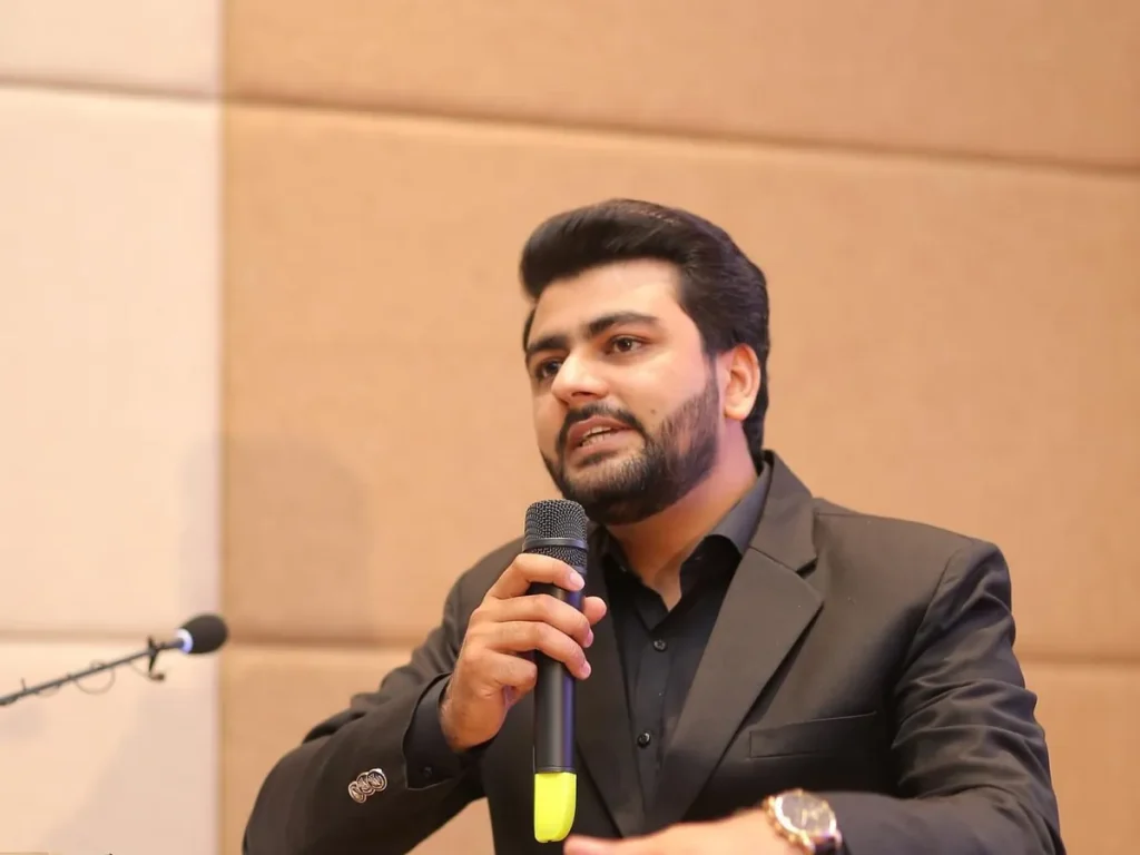 Umar Hameed speaking into a microphone at the Growth Summit
